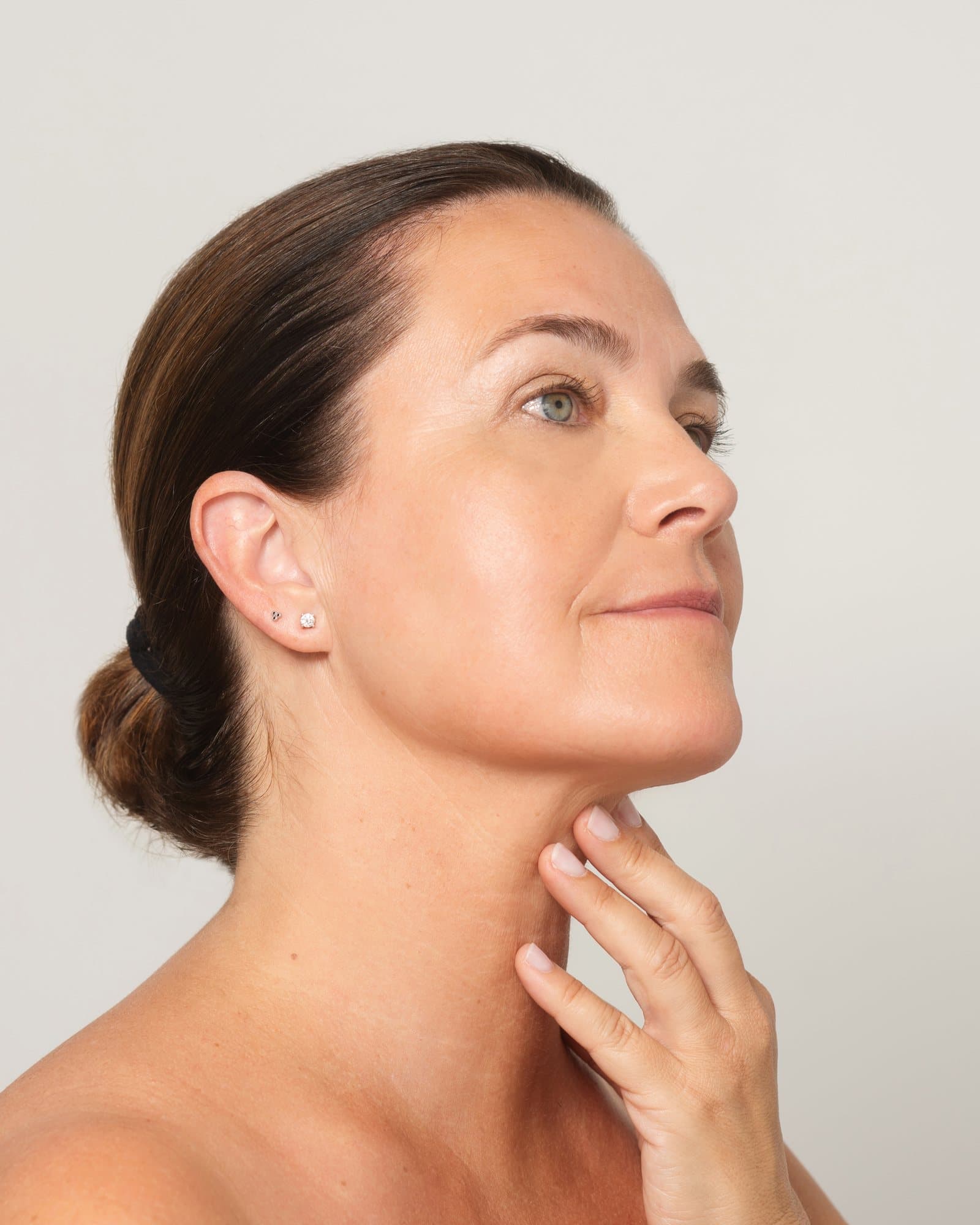 Mujer de mediana edad cuidando la piel de su cuello